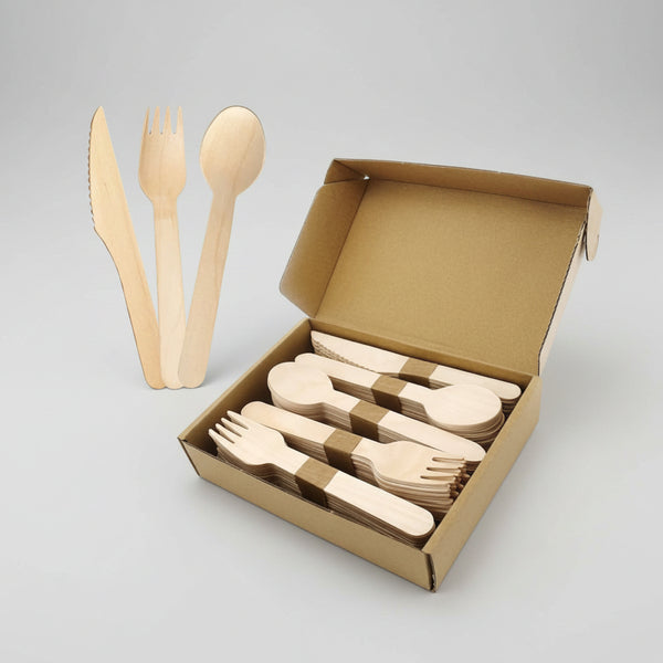 Set of wooden cutlery including knife, fork, and spoon with a cardboard box on a white background.