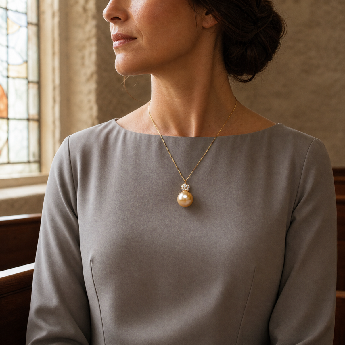 Crown Golden South Sea pearl pendant worn in a quiet chapel side aisle before a family ceremony