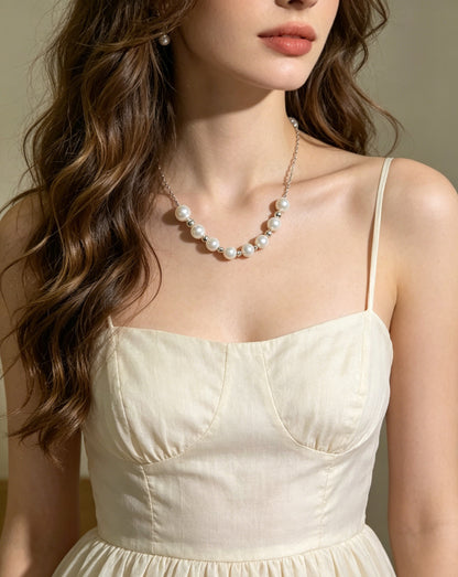 Model wearing VARI Elara nine-pearl station necklace