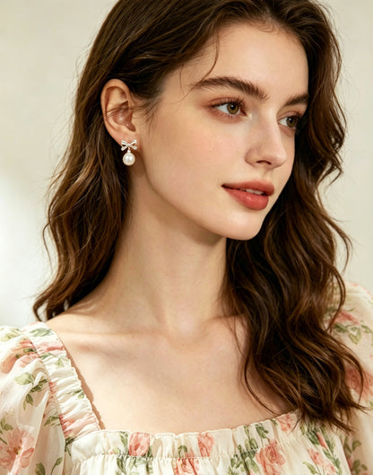 Odette white pearl bow drop earrings worn view